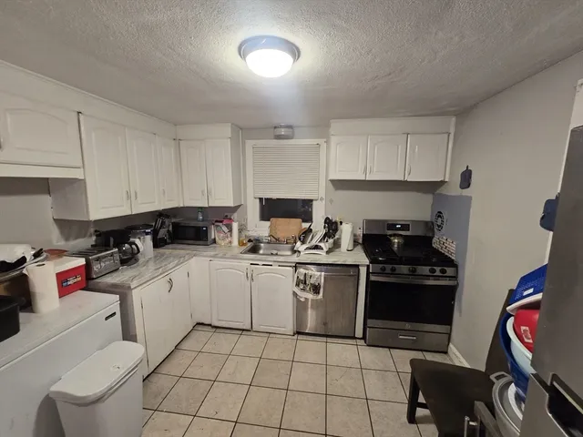 a kitchen with a sink stove and white cabinets