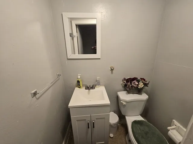 a bathroom with a toilet sink and mirror