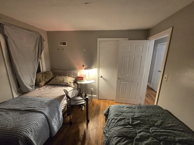 a bedroom with a bed and a refrigerator