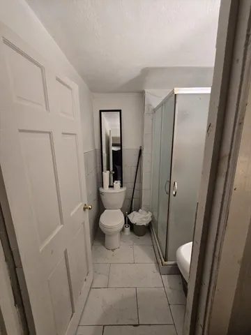 a bathroom with a toilet and a shower