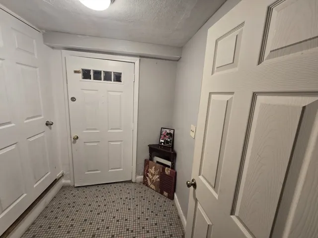 a view of a hallway with wooden floor and a cabinet