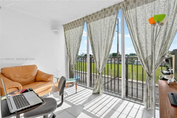 a living room with furniture and a floor to ceiling window