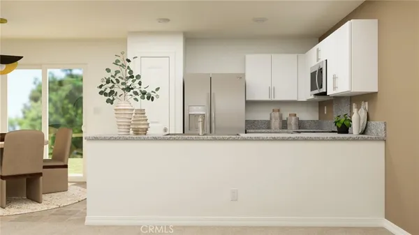 a kitchen with stainless steel appliances granite countertop a refrigerator a stove a sink and white cabinets with wooden floor