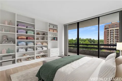 a bedroom with a bed a dresser and a large window