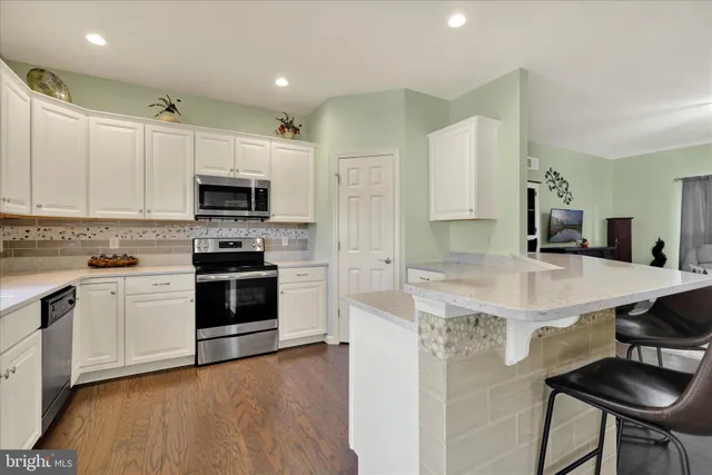 a kitchen with kitchen island a stove a sink and a refrigerator