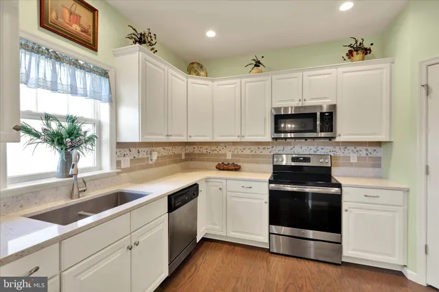 a kitchen with sink a microwave and cabinets