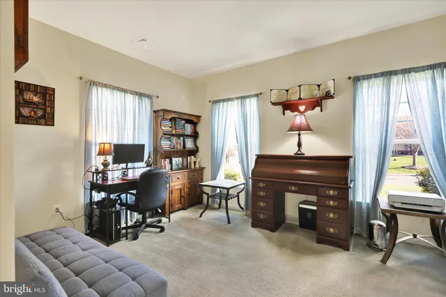 a living room with furniture a piano and a window