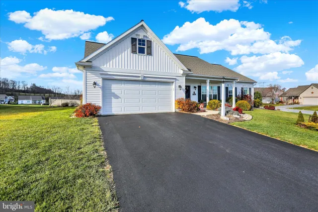 a view of a house with a yard and potted plants