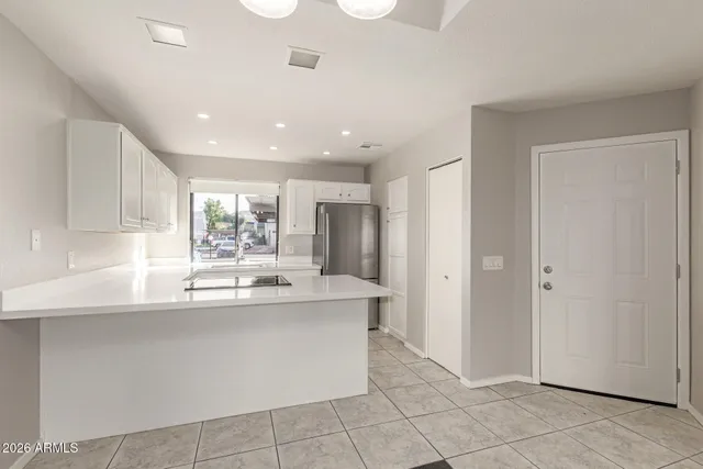 a kitchen with stainless steel appliances granite countertop a sink and a refrigerator