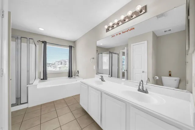 a spacious bathroom with a double vanity sink a mirror and a bathtub