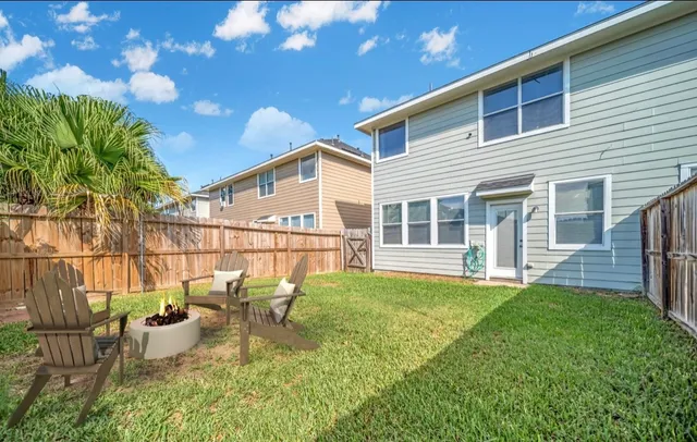 a view of a house with backyard and sitting area