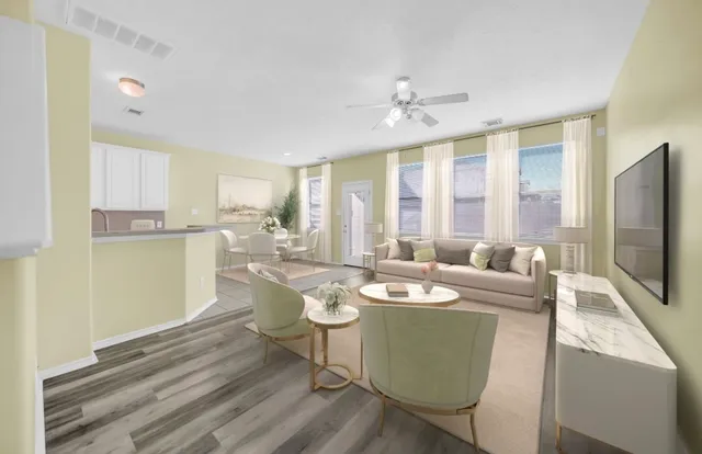 a living room with furniture a flat screen tv and large window