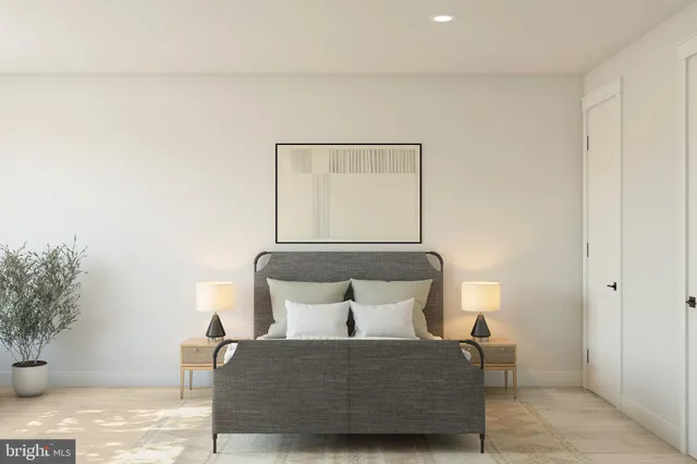 a bed sitting in a bedroom next to a window and a potted plant