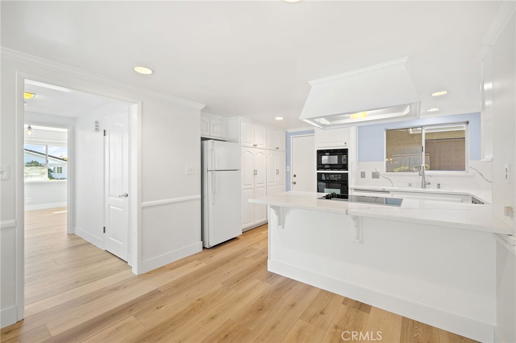 1176 Steele Drive Brea, CA 92821 - Photo 7 of 39 a large white kitchen with wooden floor and a refrigerator