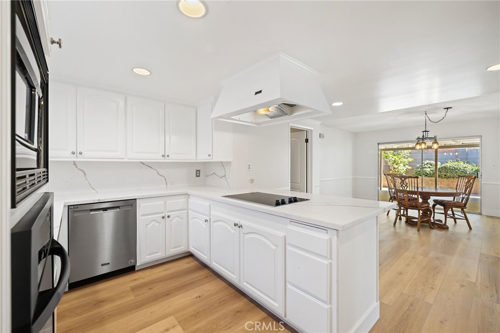 1176 Steele Drive Brea, CA 92821 - Photo 9 of 39 a kitchen with a sink dishwasher a stove a dining table and chairs with wooden floor