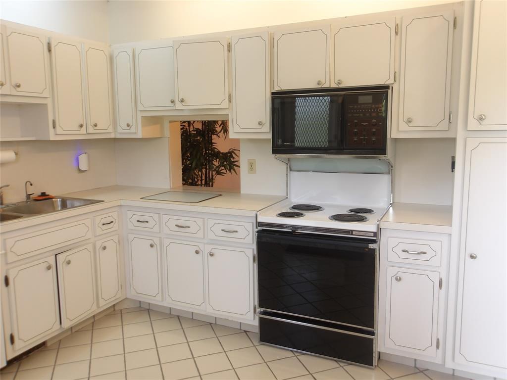 6731 Cypress Road, Unit 309 Plantation, FL 33317 - Photo 3 of 24 a kitchen with white cabinets and stainless steel appliances