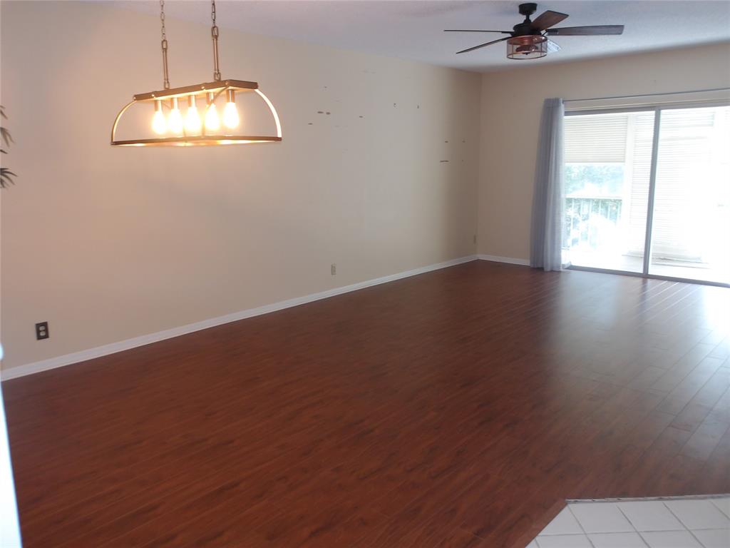 6731 Cypress Road, Unit 309 Plantation, FL 33317 - Photo 4 of 24 an empty room with a chandelier fan and windows