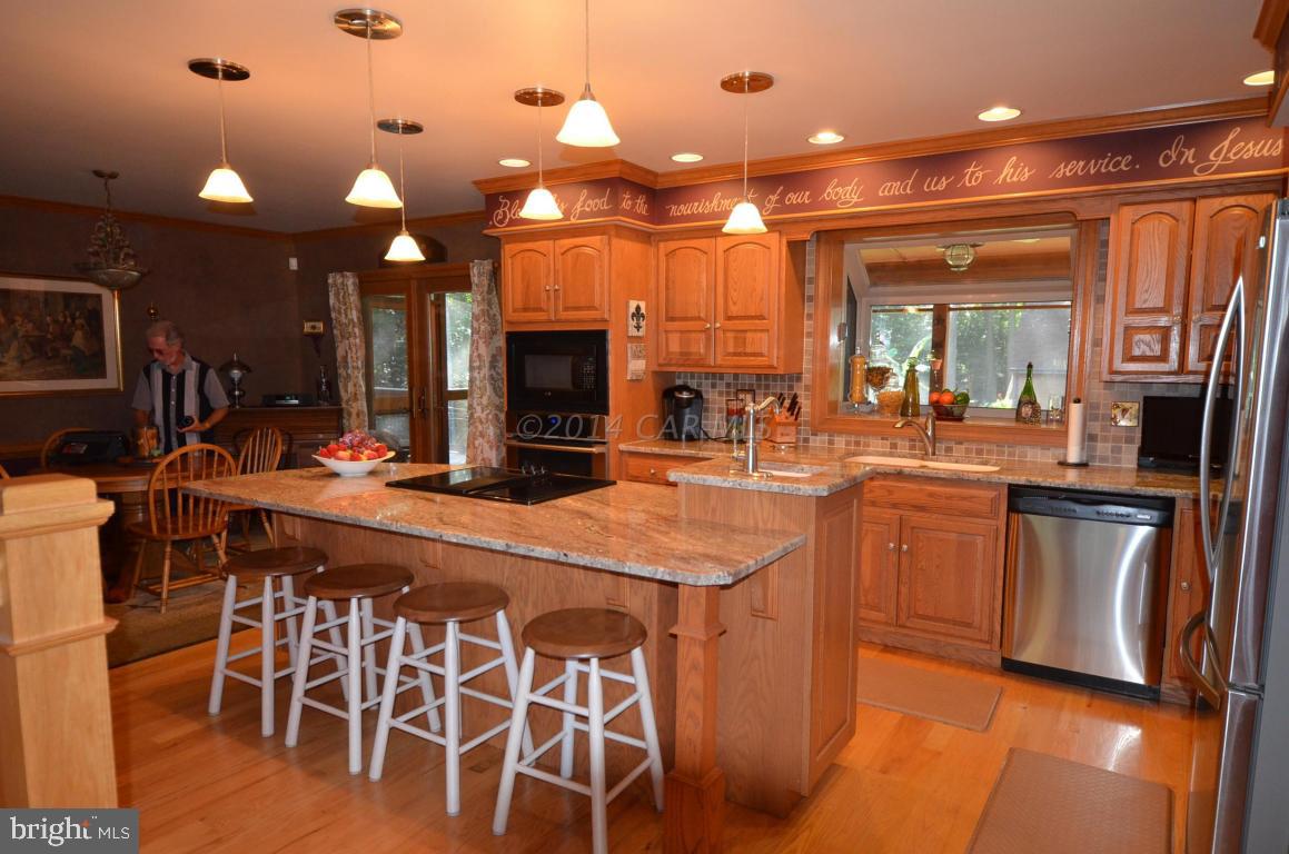 309 Silva Road Stockton, MD 21864 - Photo 18 of 67 a kitchen with stainless steel appliances kitchen island granite countertop a table chairs sink and cabinets