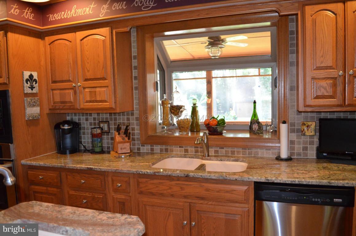 309 Silva Road Stockton, MD 21864 - Photo 19 of 67 a kitchen with stainless steel appliances granite countertop a sink and wooden cabinets