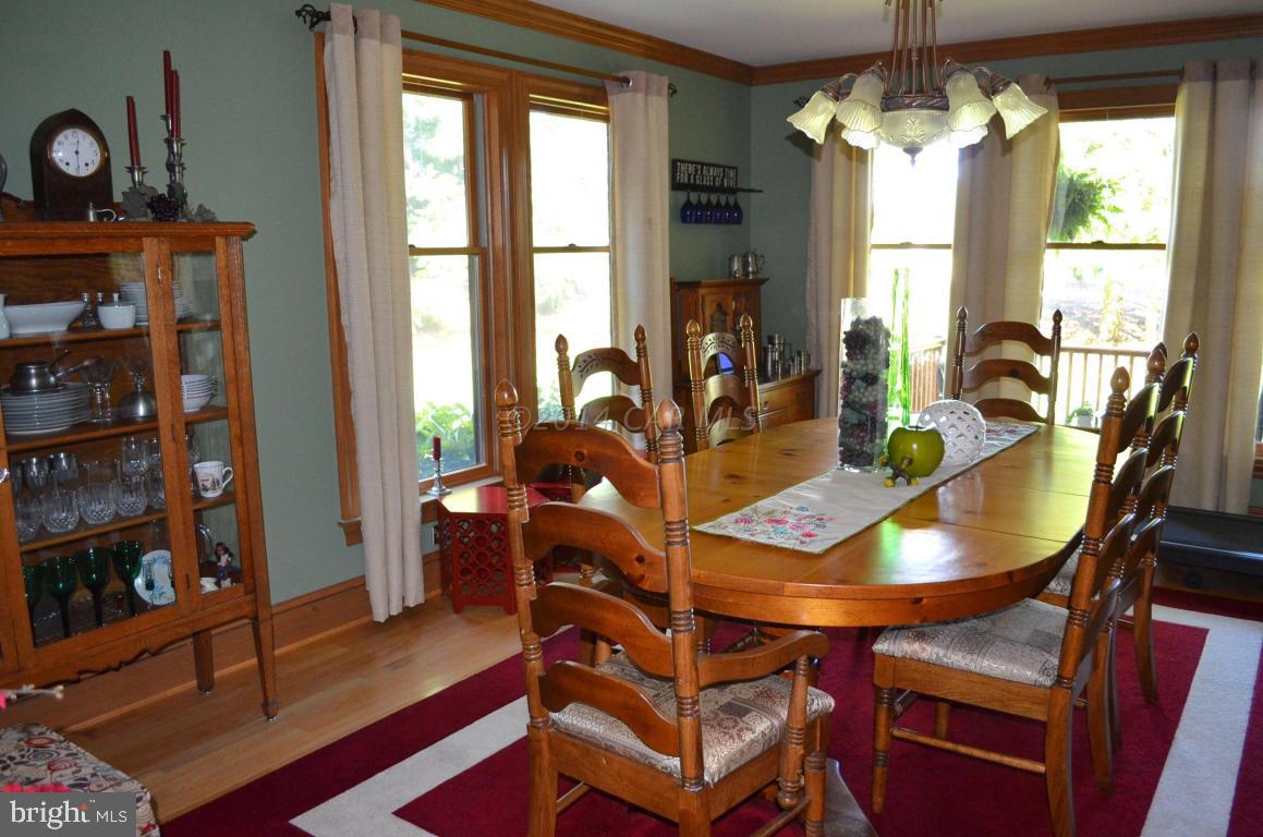 309 Silva Road Stockton, MD 21864 - Photo 29 of 67 a dining room with furniture a chandelier and wooden floor