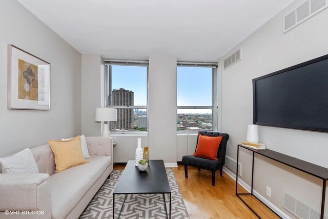 655 West Irving Park Road, Unit 2311 Chicago, IL 60613 - Photo 4 of 21 a living room with furniture and a flat screen tv