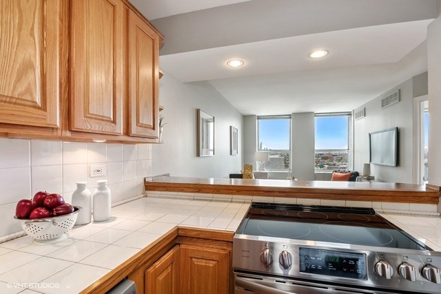 655 West Irving Park Road, Unit 2311 Chicago, IL 60613 - Photo 6 of 21 a kitchen with a stove and a white cabinets