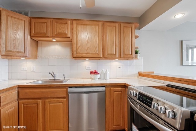 655 West Irving Park Road, Unit 2311 Chicago, IL 60613 - Photo 7 of 21 a kitchen with stainless steel appliances granite countertop a sink stove and cabinets