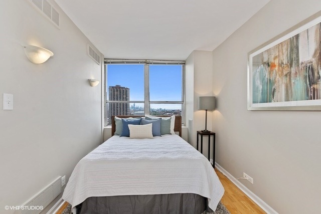 655 West Irving Park Road, Unit 2311 Chicago, IL 60613 - Photo 8 of 21 a bedroom with a bed and a painting on the wall