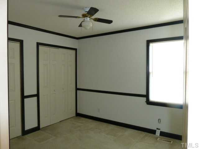 5608 Spring Pines Way Raleigh, NC 27616 - Photo 10 of 15 a view of empty room with wooden floor and fan