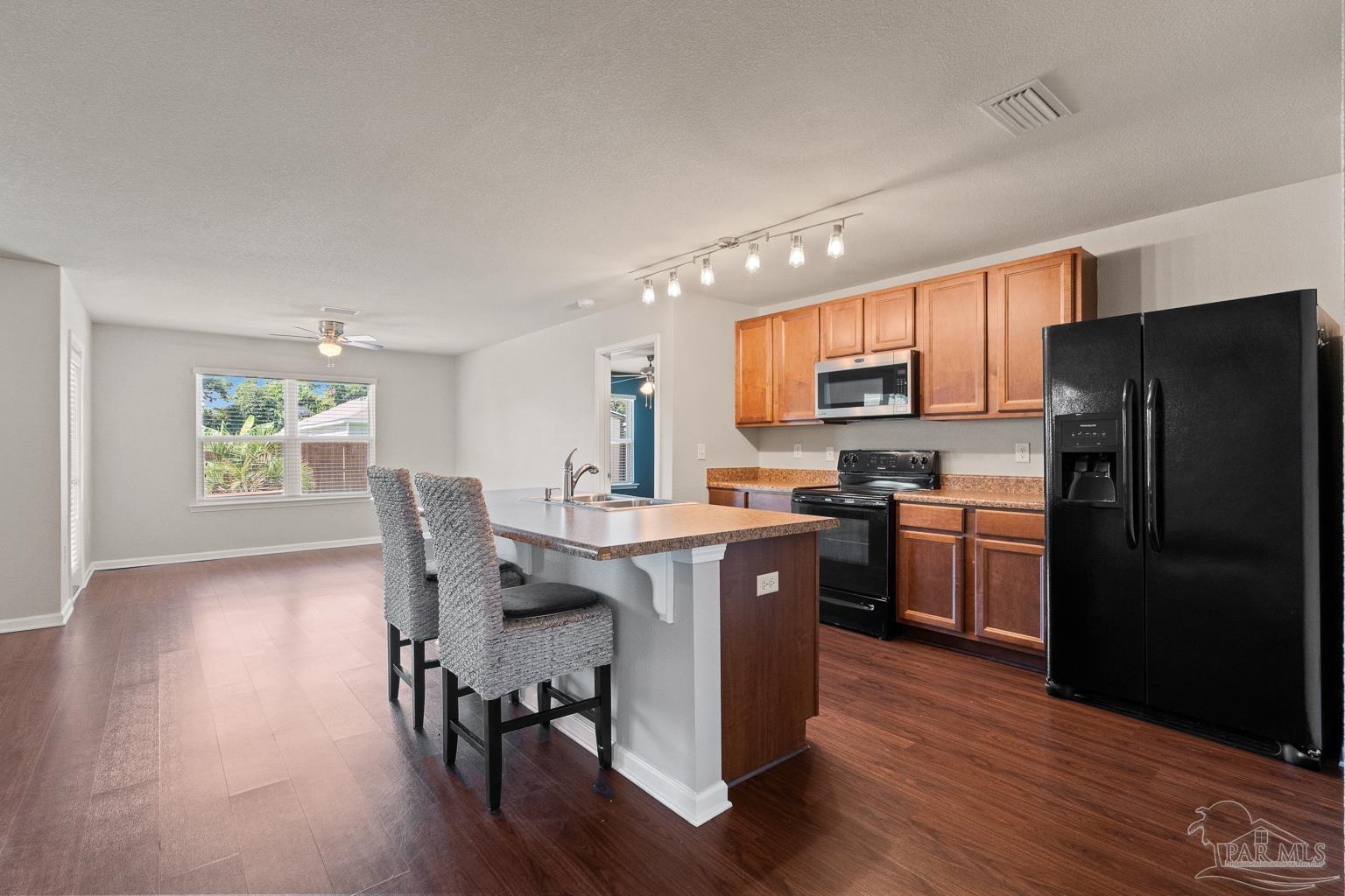 17438 Harding Drive Foley, AL 36535 - Photo 18 of 56 a kitchen with a table chairs refrigerator and microwave