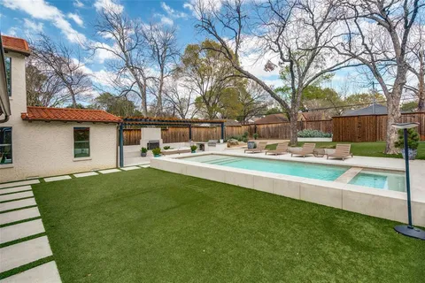 a view of a house with backyard and tree