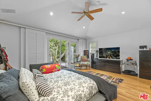 a bedroom with a bed a couch and a flat screen tv
