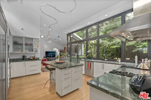 a kitchen with stainless steel appliances granite countertop sink stove and refrigerator