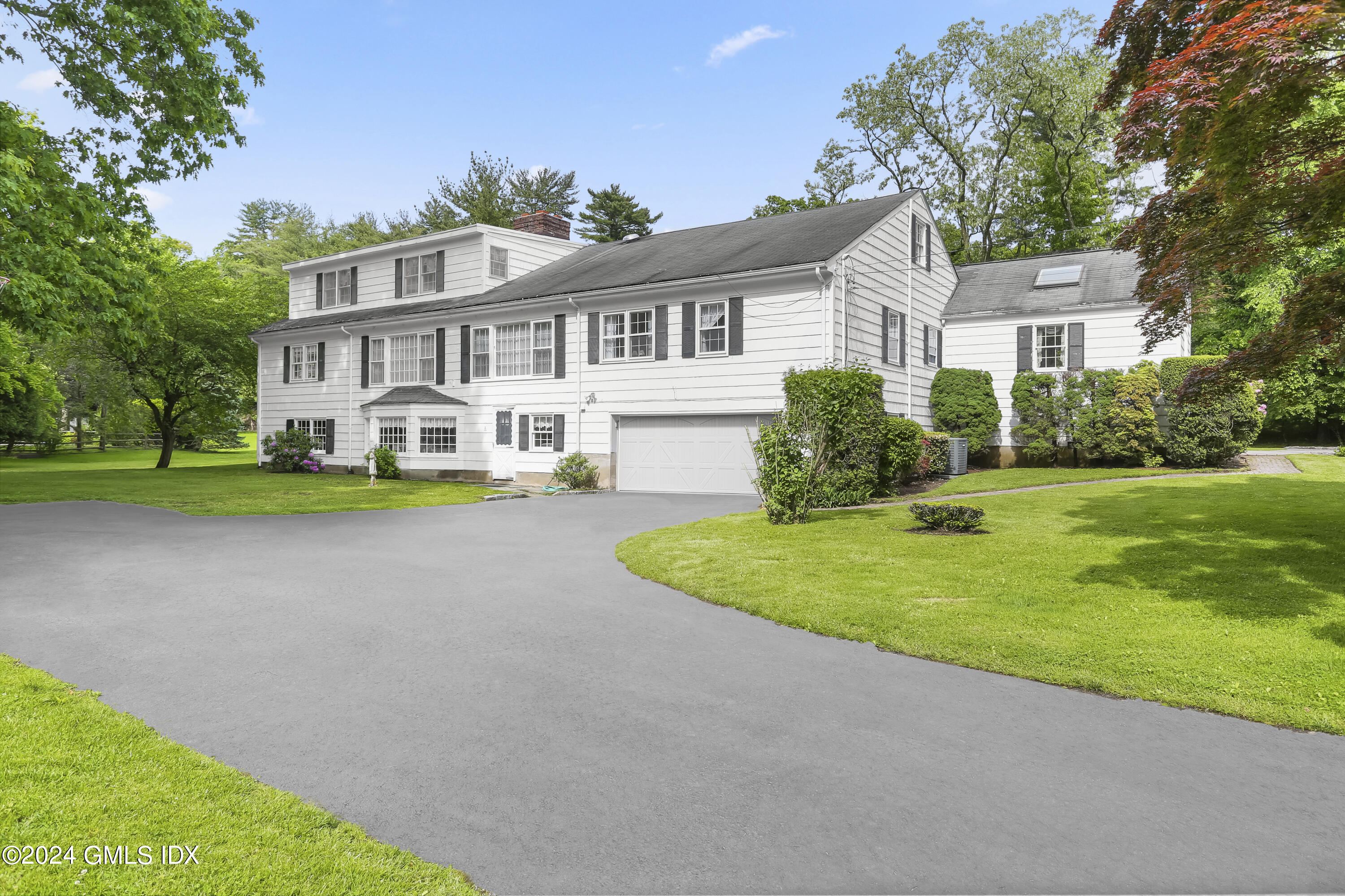 34 Hill Road Greenwich, CT 06830 - Photo 16 of 22 a front view of a house with a yard and garage