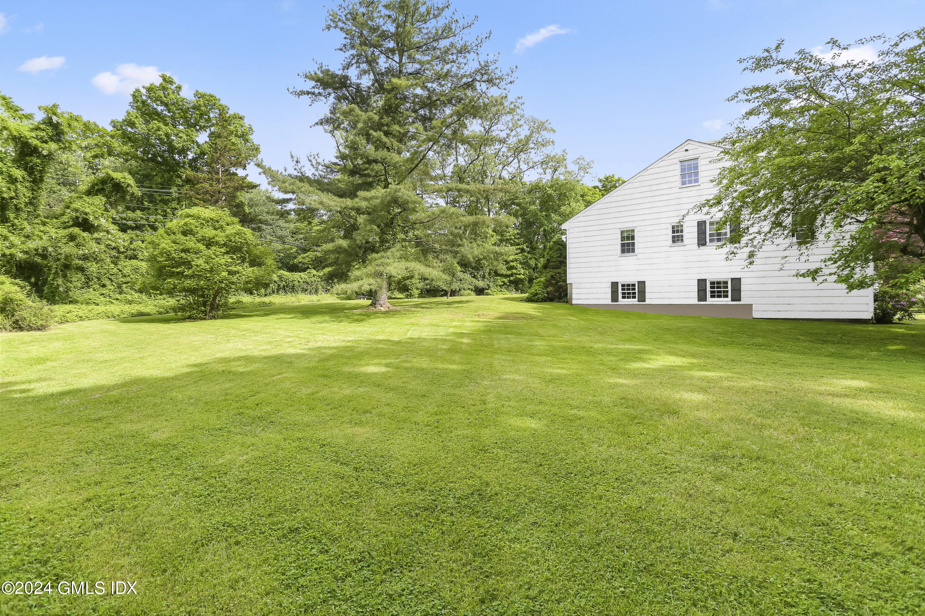 34 Hill Road Greenwich, CT 06830 - Photo 18 of 22 a view of a house with a big yard and large trees