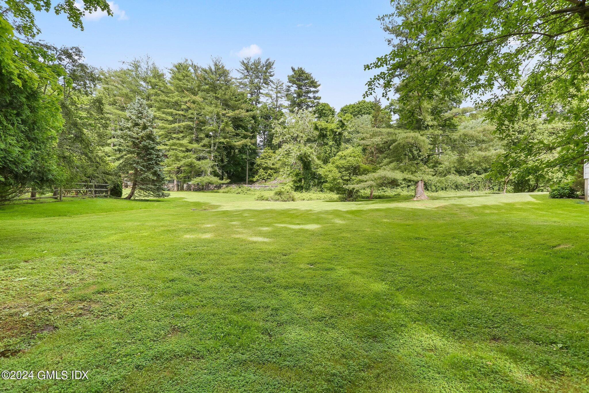34 Hill Road Greenwich, CT 06830 - Photo 19 of 22 a view of a grassy field with trees in the background