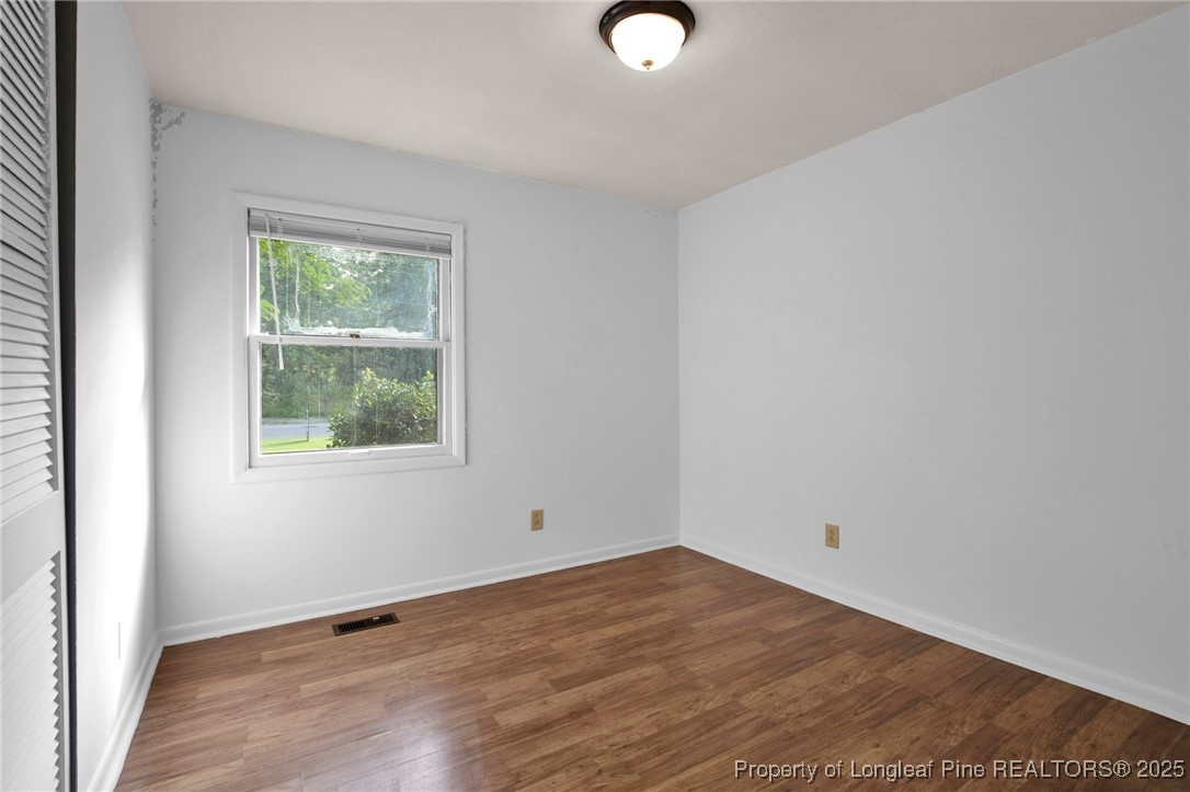 417 Perth Street Fayetteville, NC 28314 - Photo 17 of 30 an empty room with wooden floor and windows