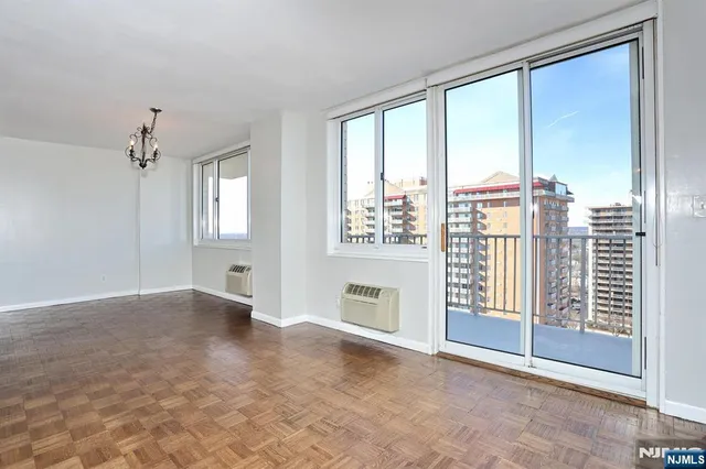an empty room with windows and balcony