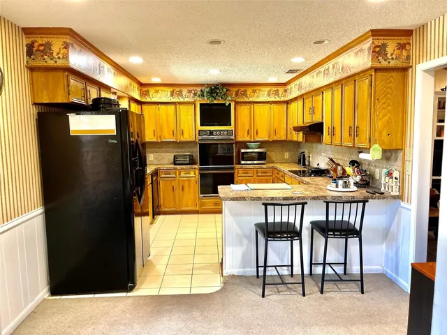 a kitchen with a table chairs refrigerator and cabinets