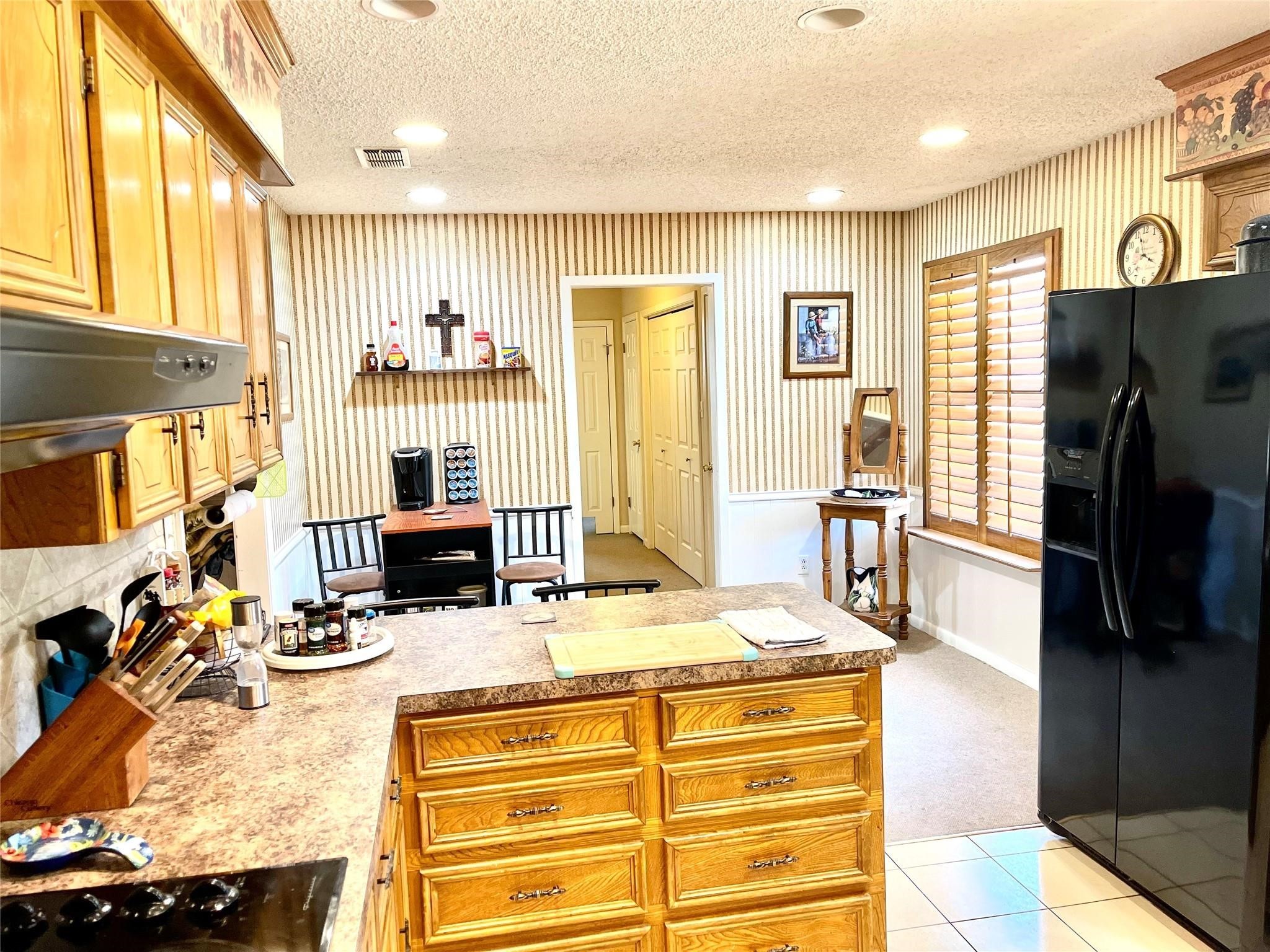 710 South Main Street Coolidge, TX 76635 - Photo 12 of 36 a room with stainless steel appliances kitchen island granite countertop a refrigerator a stove and a dining table with wooden floor