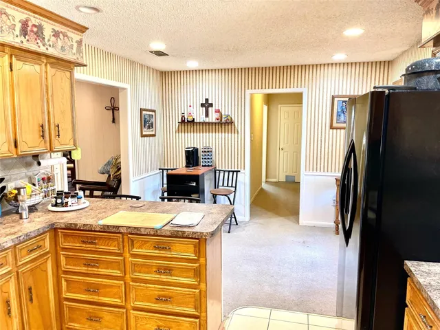 a view of a kitchen with a sink a refrigerator and a view of living room