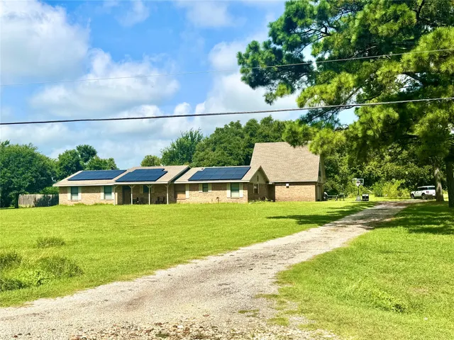 a front view of a house with a yard and trees
