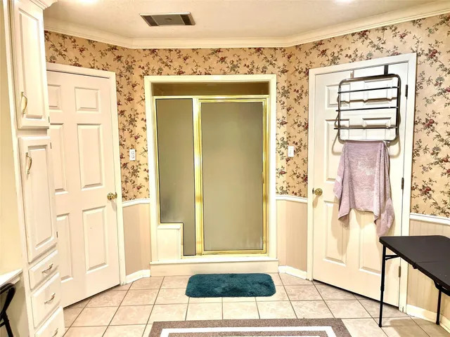 a spacious bedroom with a large window and a walk in closet