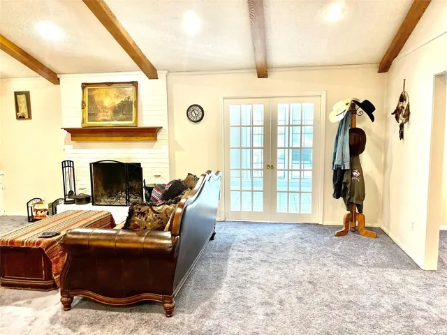 a living room with furniture a fireplace and a floor to ceiling window