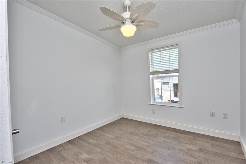 777 Walkerbilt Road, Unit 27 Naples, FL 34110 - Photo 13 of 31 an empty room with wooden floor and windows