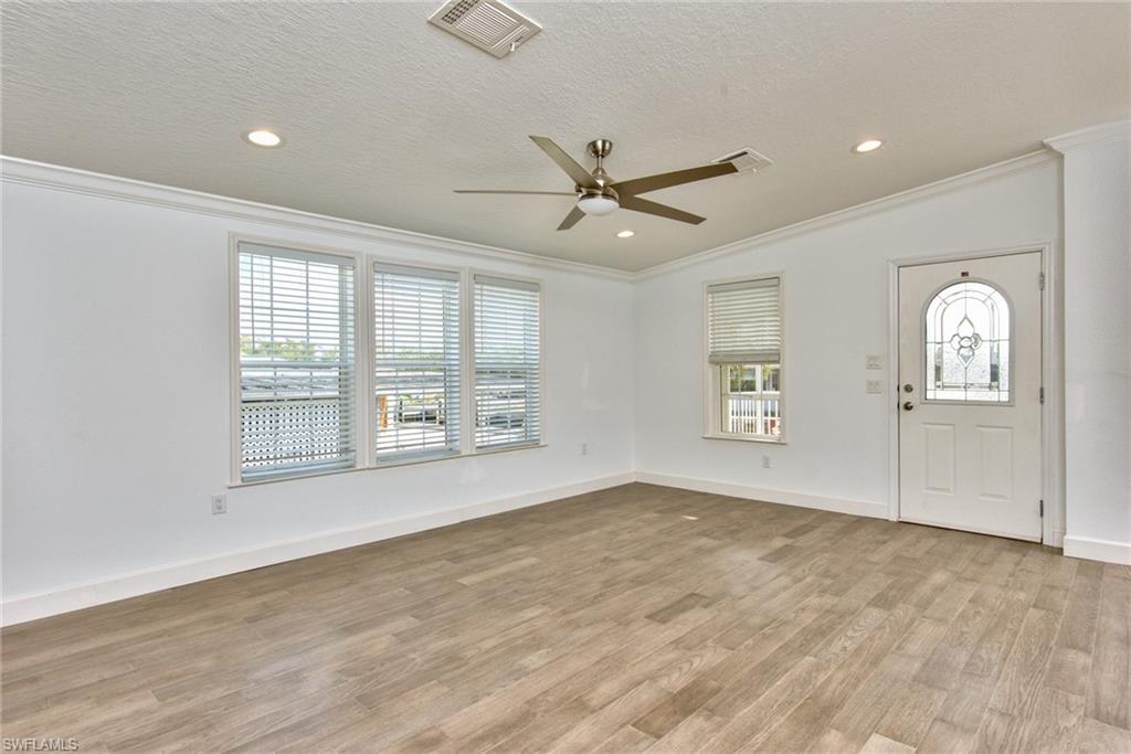 777 Walkerbilt Road, Unit 27 Naples, FL 34110 - Photo 17 of 31 a view of an empty room with a window and wooden floor