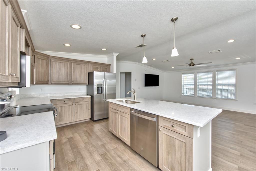 777 Walkerbilt Road, Unit 27 Naples, FL 34110 - Photo 25 of 31 a kitchen with a sink stove and refrigerator