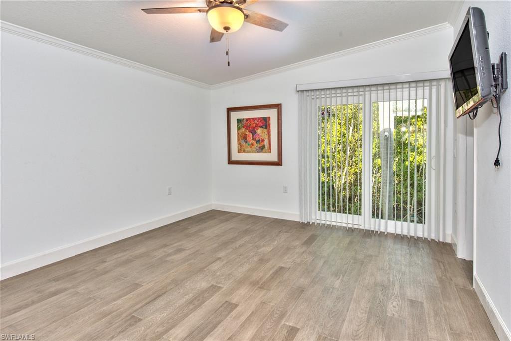 777 Walkerbilt Road, Unit 27 Naples, FL 34110 - Photo 29 of 31 an empty room with wooden floor and windows