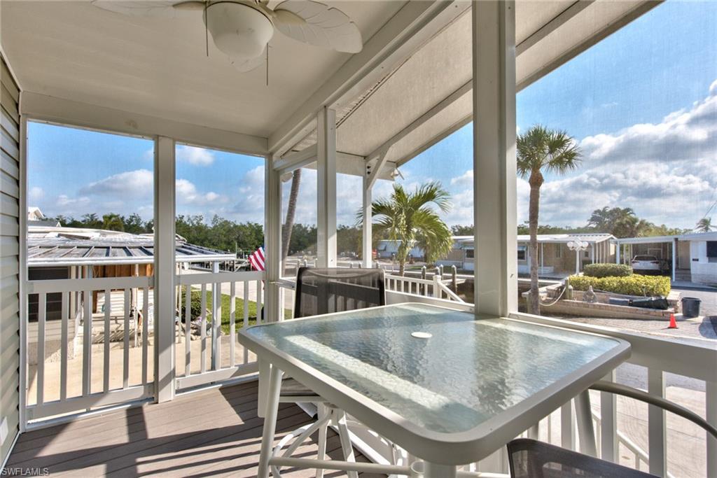 777 Walkerbilt Road, Unit 27 Naples, FL 34110 - Photo 7 of 31 a dining room with wooden floor and large windows