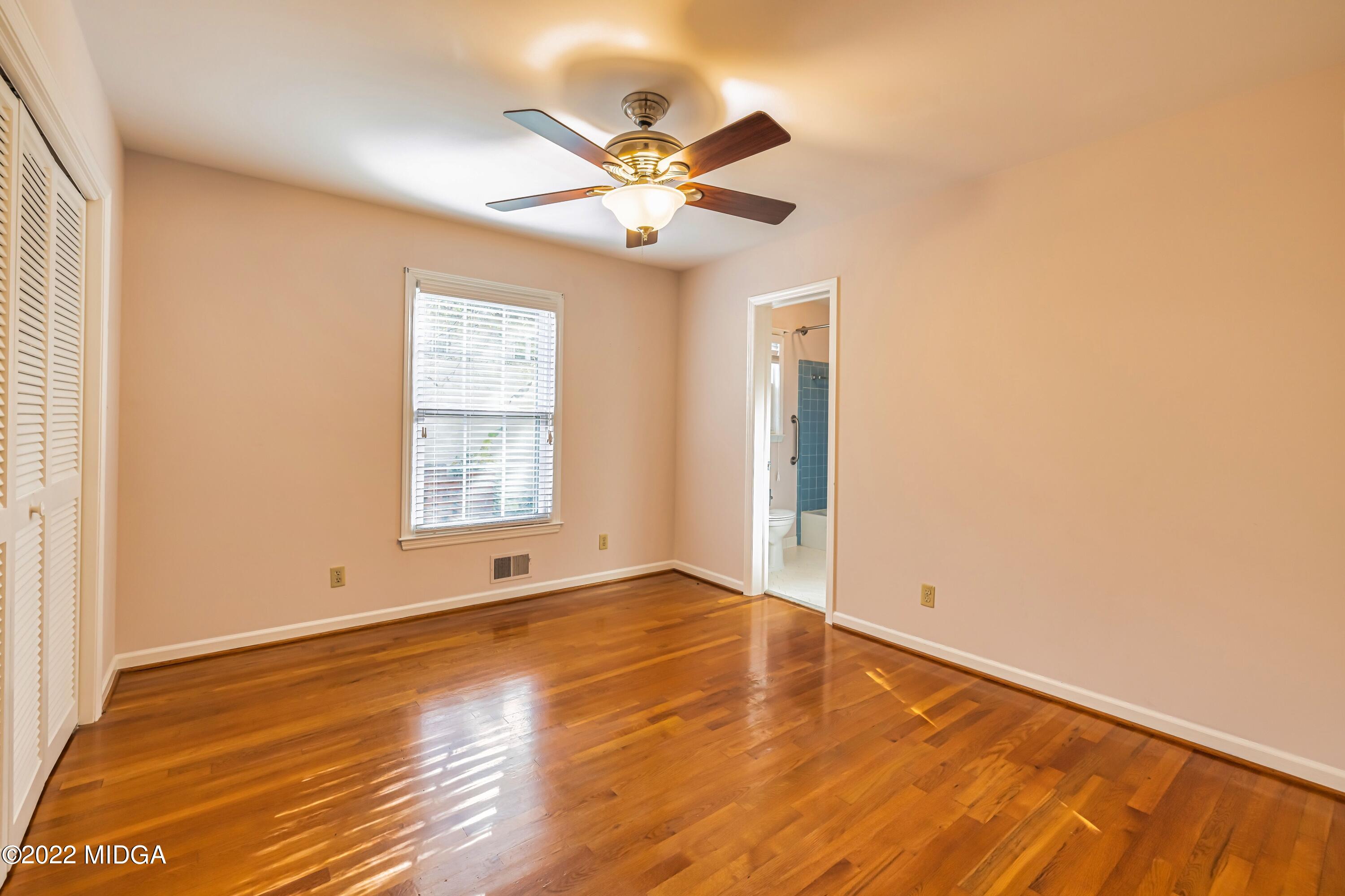 201 Larcom Lane Griffin, GA 30224 - Photo 33 of 64 an empty room with wooden floor chandelier fan and windows